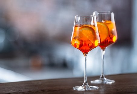 Two glasses of Aperol Spritz on a wooden bar | MSC Cruises Two glasses of Aperol Spritz on a wooden bar | MSC Cruises