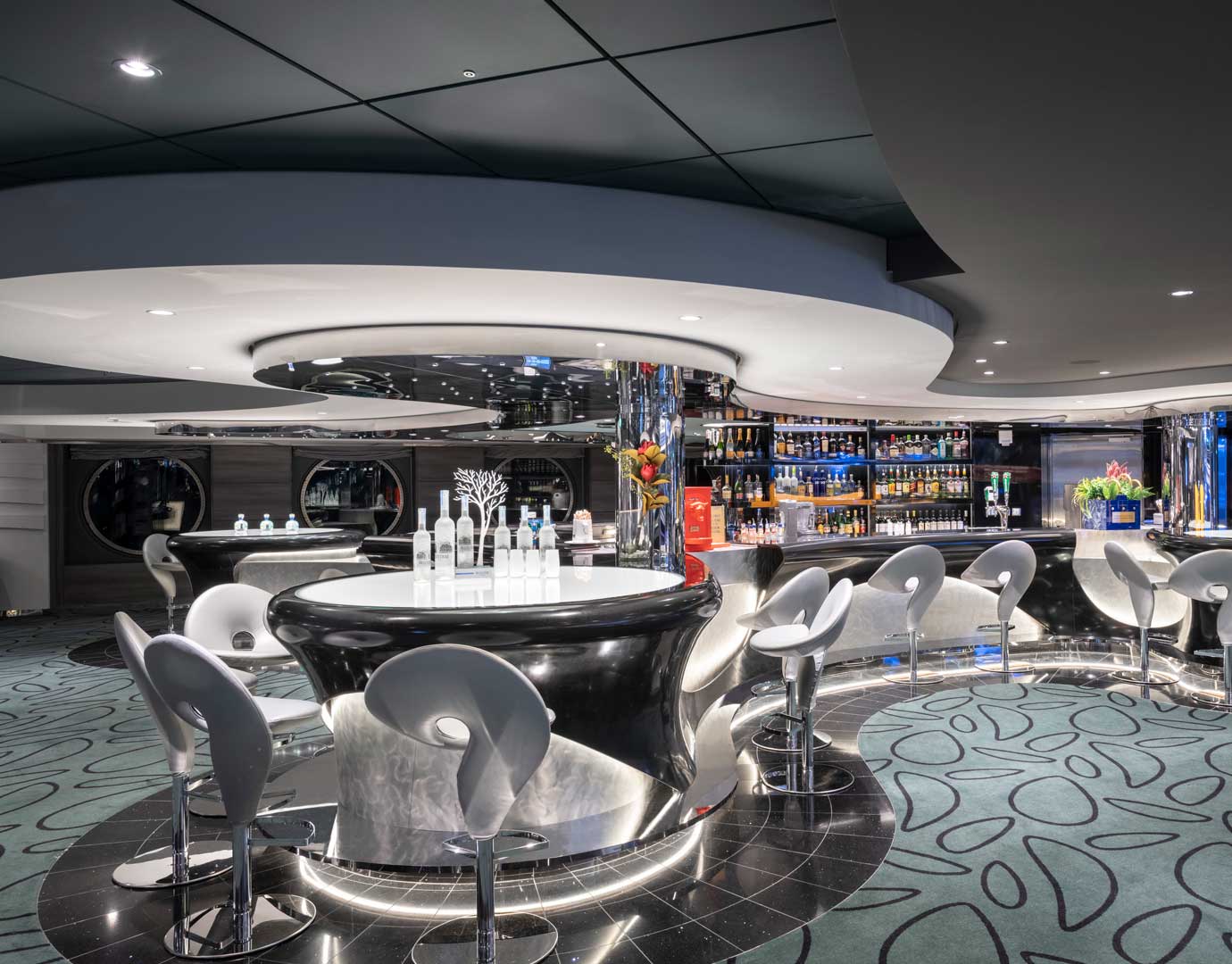 Modern cruise ship lounge bar with sleek design and illuminated seating | MSC Cruises Modern cruise ship lounge bar with sleek design and illuminated seating | MSC Cruises