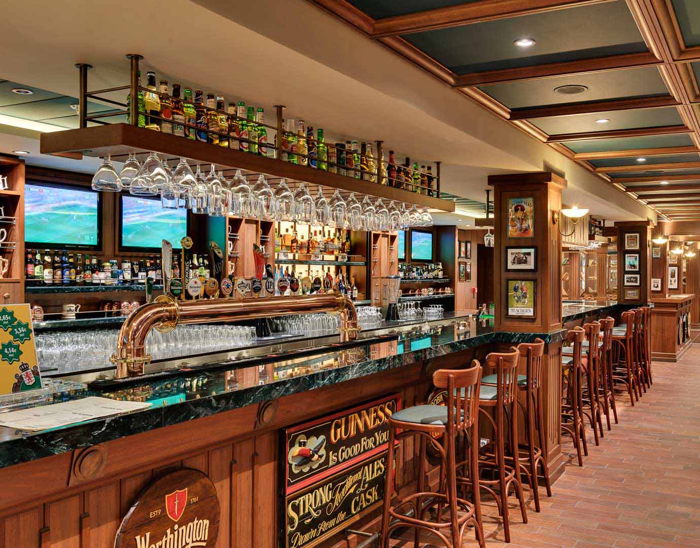An elegant onboard bar with wooden decor and a variety of drinks on display | MSC Cruises An elegant onboard bar with wooden decor and a variety of drinks on display | MSC Cruises